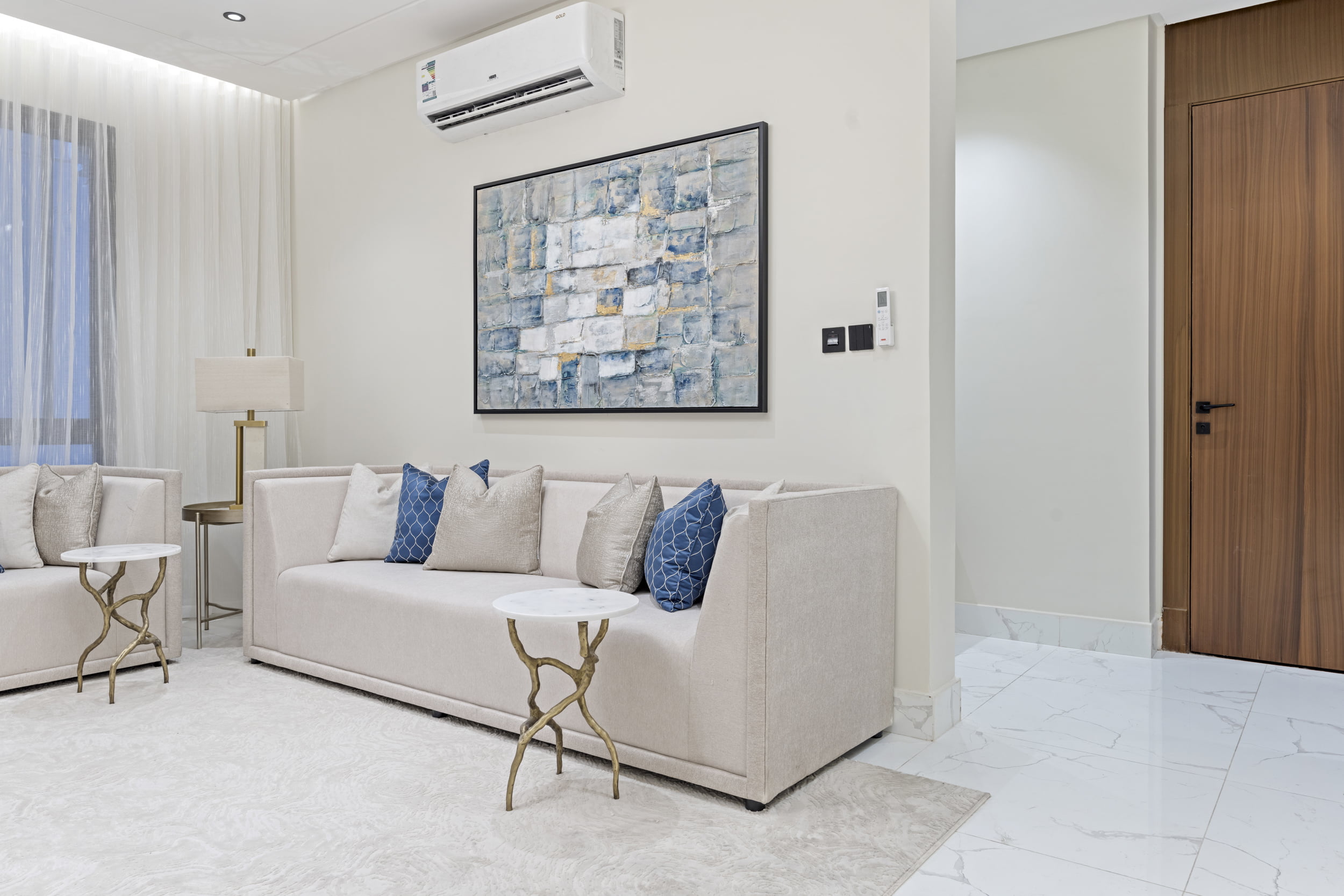 large white sofa on living room with blue pillows and blue painting