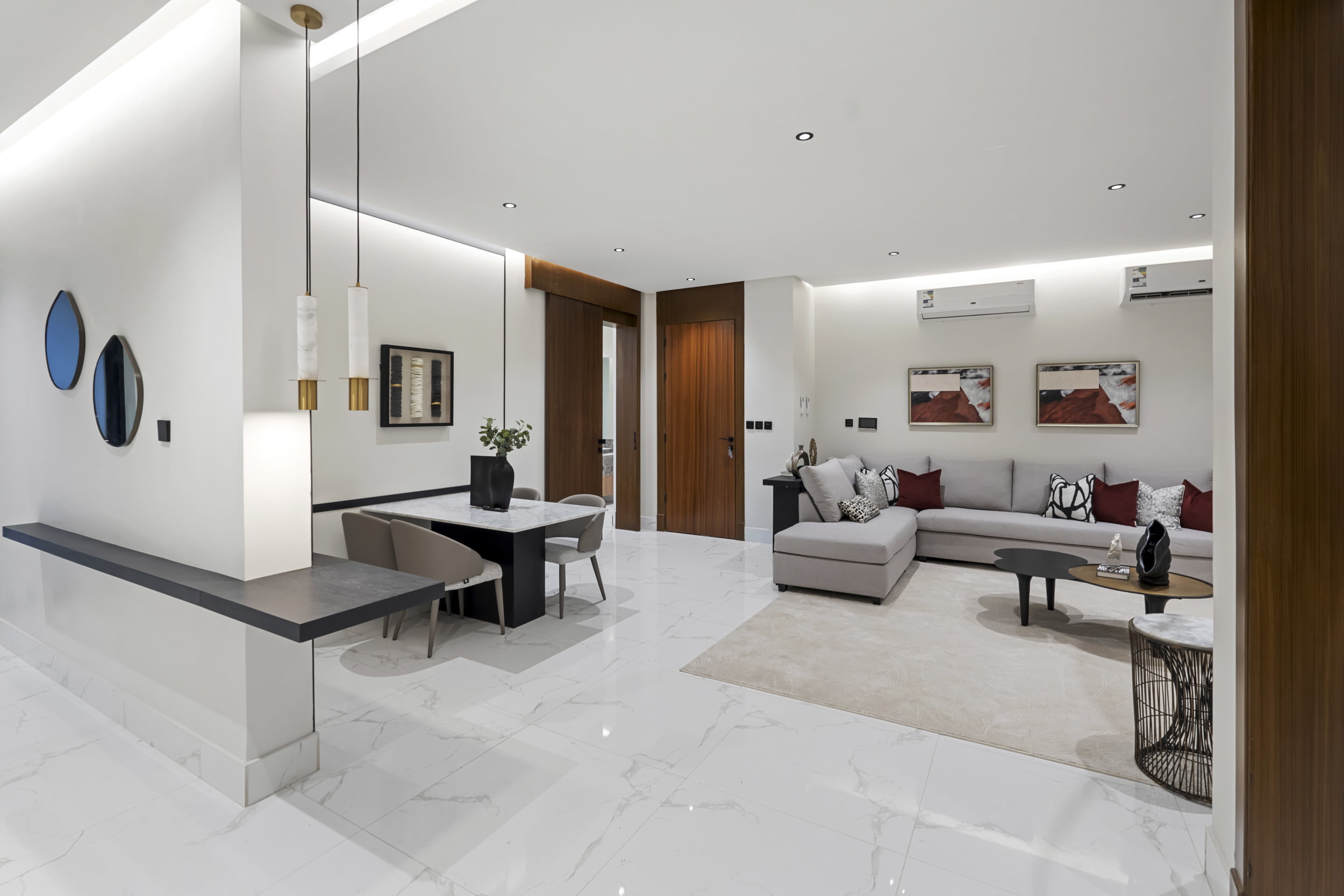 view of living room white and red furniture with red paintings on the wall and mirrors