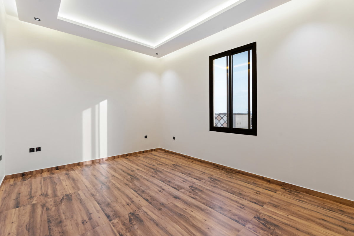 small bedroom with wooden floor and sunny window